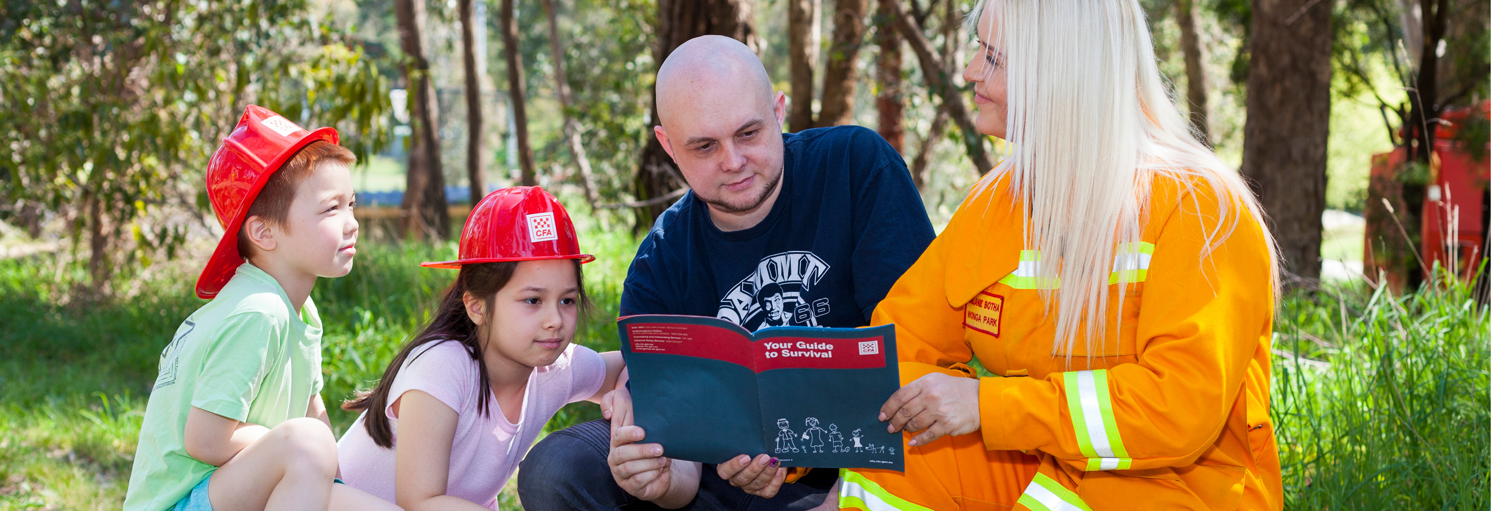 A son, daughter and father learning about emergency preparedness with a female firefighter.